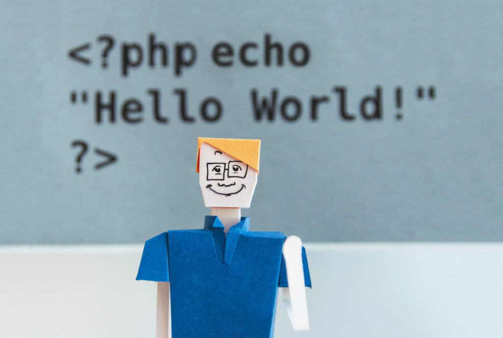 Eine Papierfigur eines Mannes vor dem Hintergrund des PHP-Codes