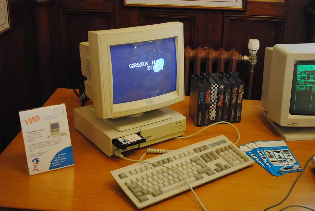 Ein alter Computer mit einer Tastatur und einer Kassette auf einem Schreibtisch