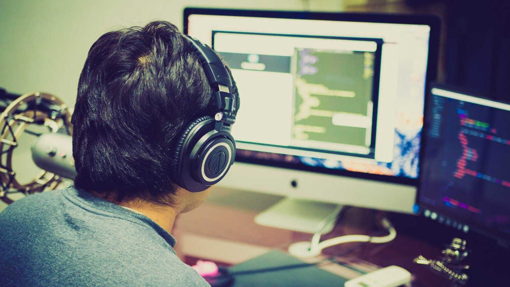 A man in headphones working at a computer