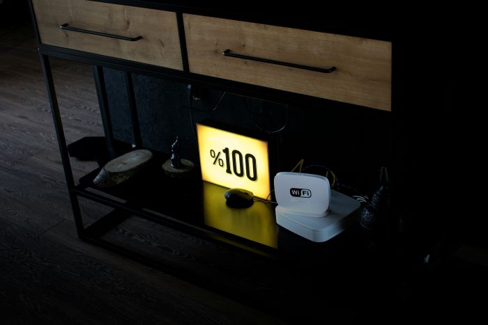 On the bottom shelf of the dresser there is a glowing sign that says “100%”